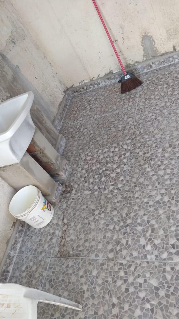 Piso cinza recém-assentado em área de serviço com tanque